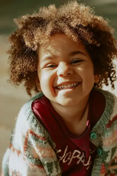 Criança sorrindo em atendimento de odontopediatria