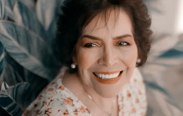 Paciente sorrindo com reabilitação por prótese dentária